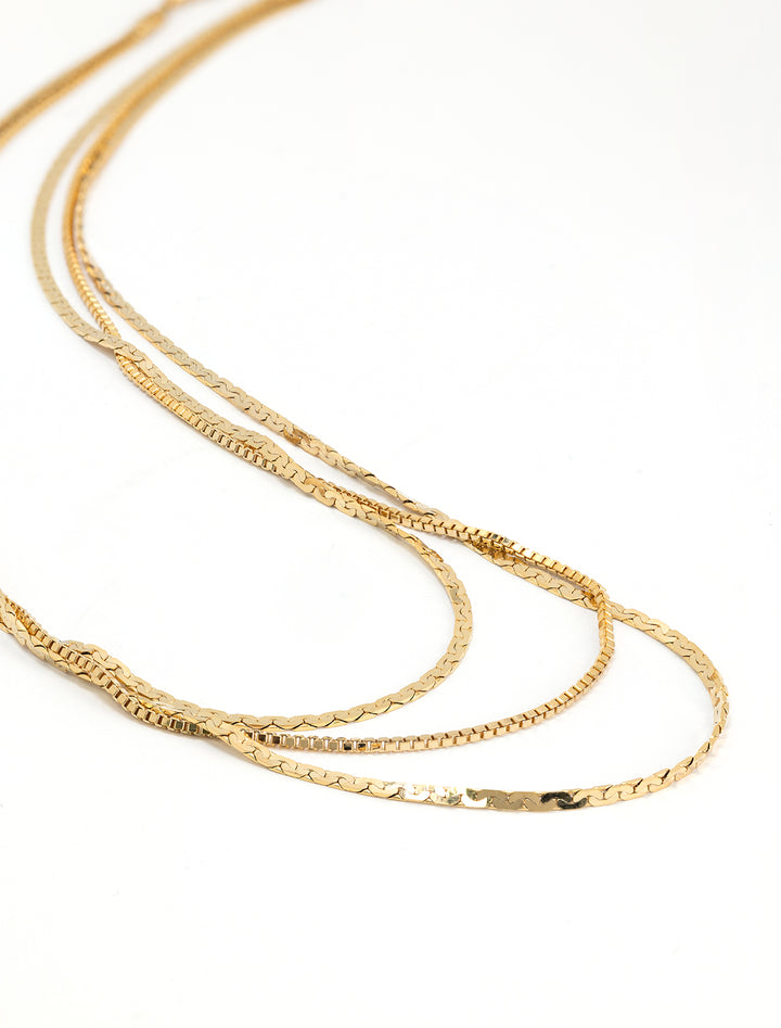 Stylized laydown of AV Max's triple layer dainty disco necklace.