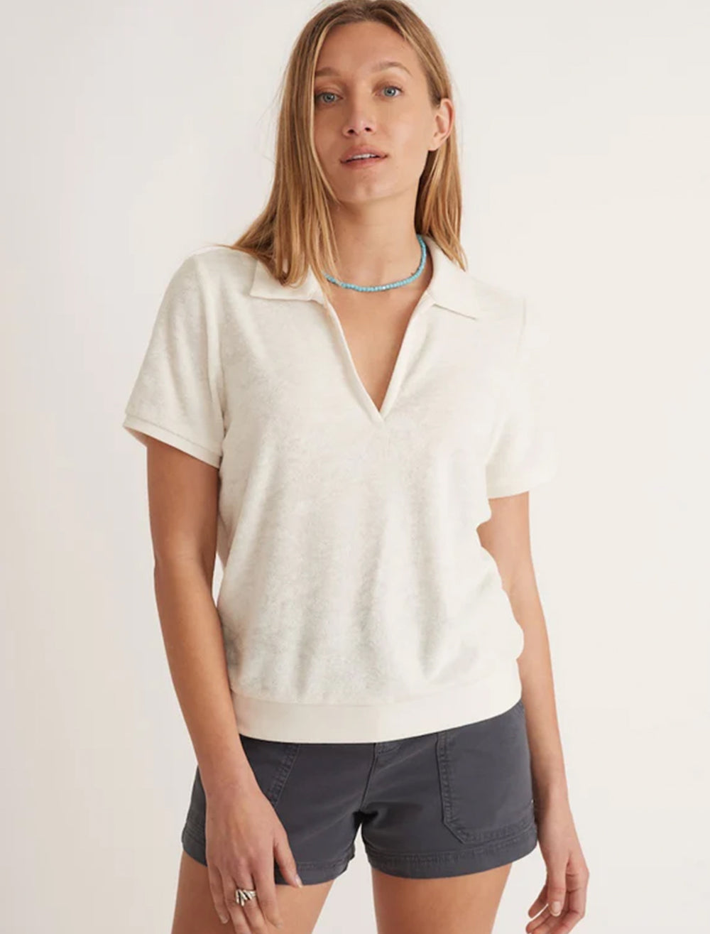 Model wearing Marine Layer's vintage polo in antique white.