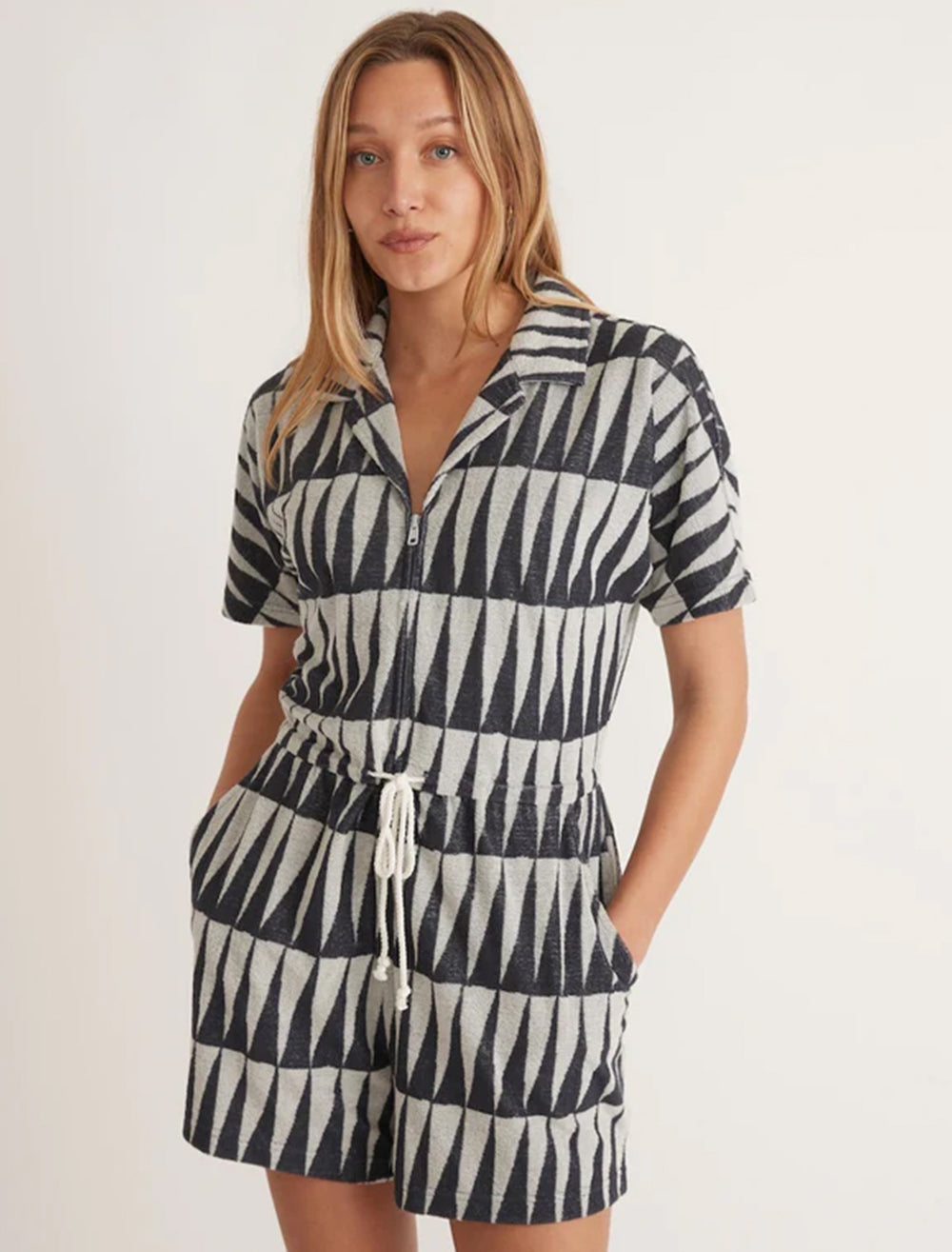 Model wearing Marine Layer's terry out romper in black and white geo triangle.