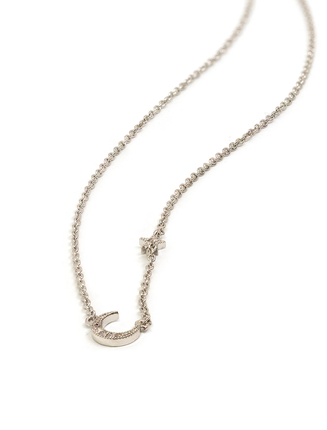 Stylized laydown of Tai Jewelry's moon and star with cz silver necklace.