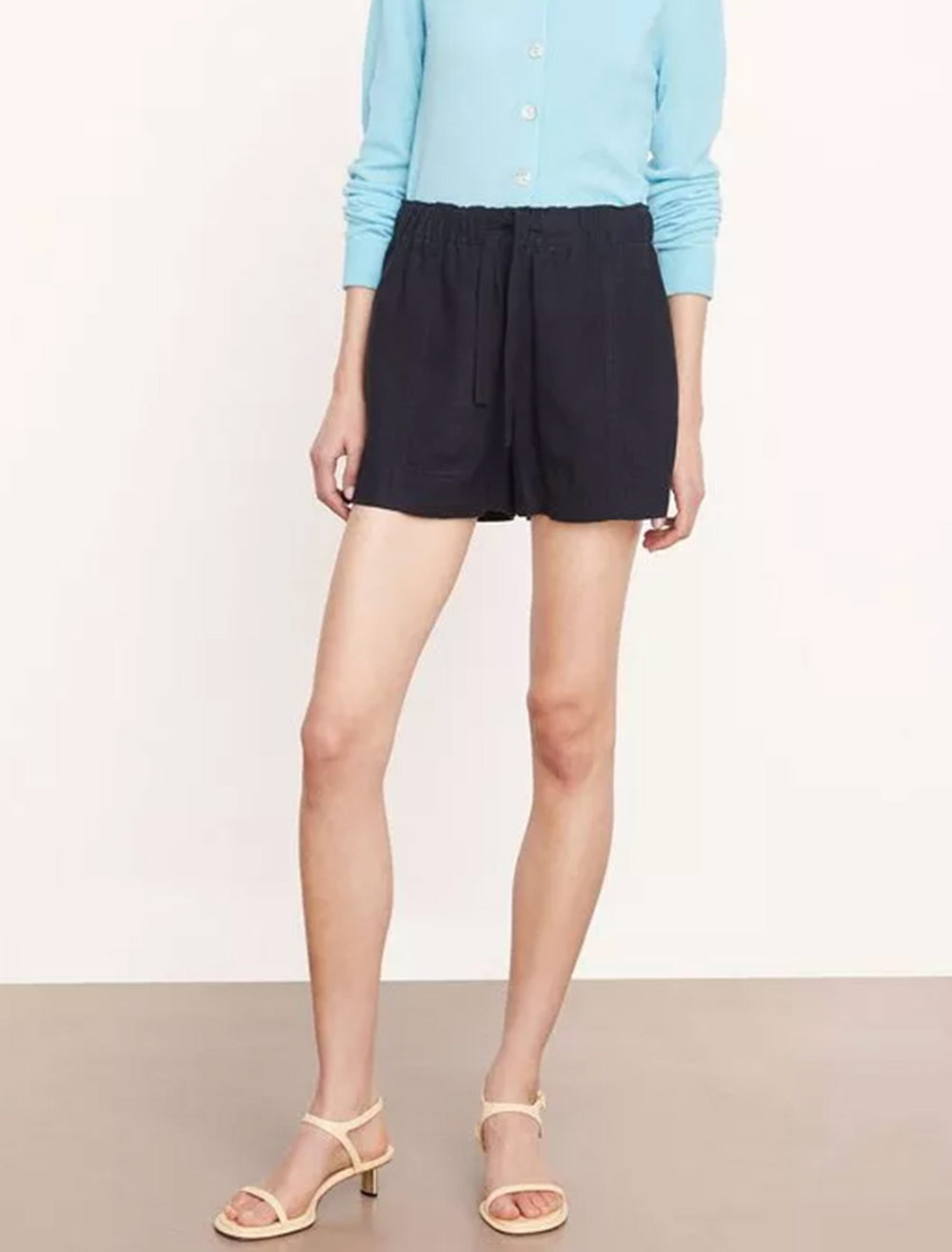 Model wearing Vince's mid waist tie front pull on short in coastal.