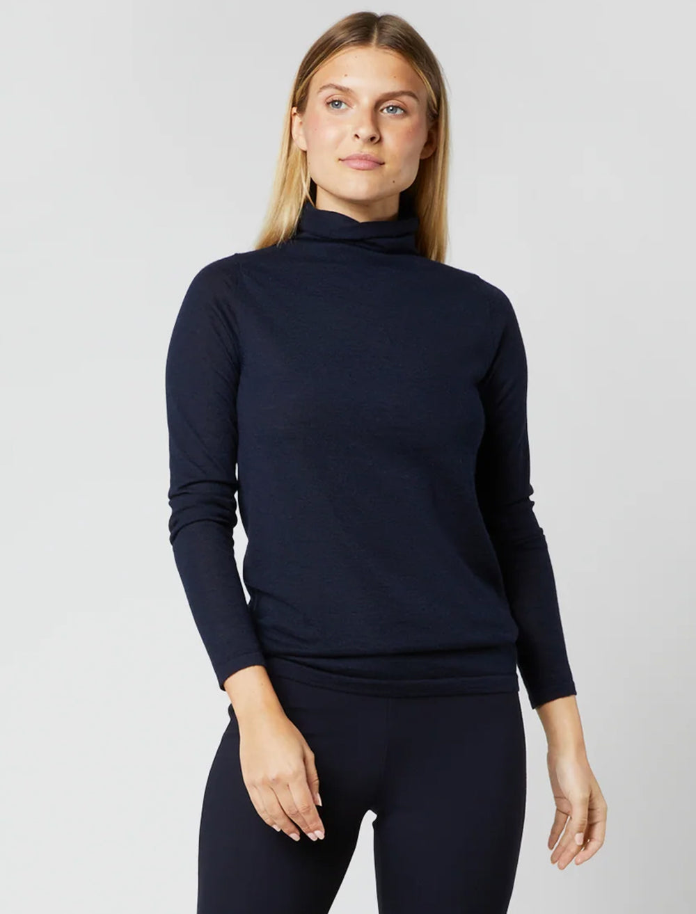 Model wearing Ann Mashburn's funnel neck cashmere sweater in navy.