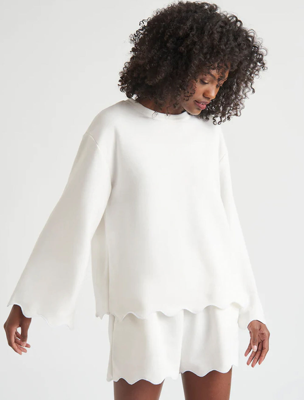 Model wearing Splendid's nori scallop trim sweatshirt in white.