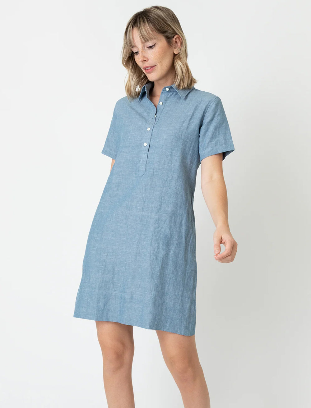 Model wearing Ann Mashburn's short sleeved popover dress in light chambray.