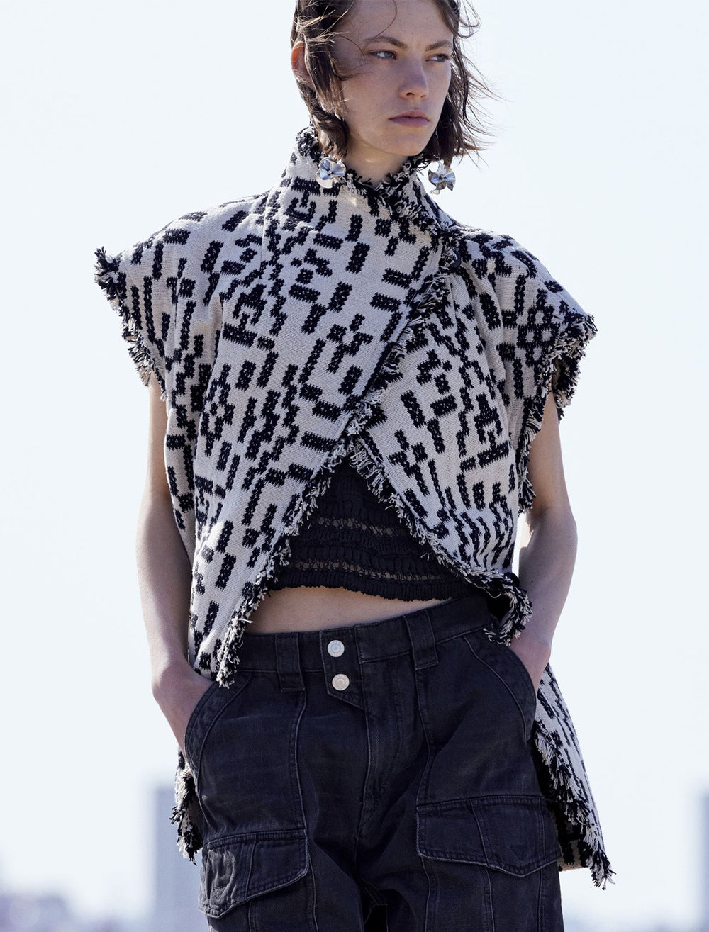 Model wearing Isabel Marant Etoile's faith jacket in black and white without sleeves attached.