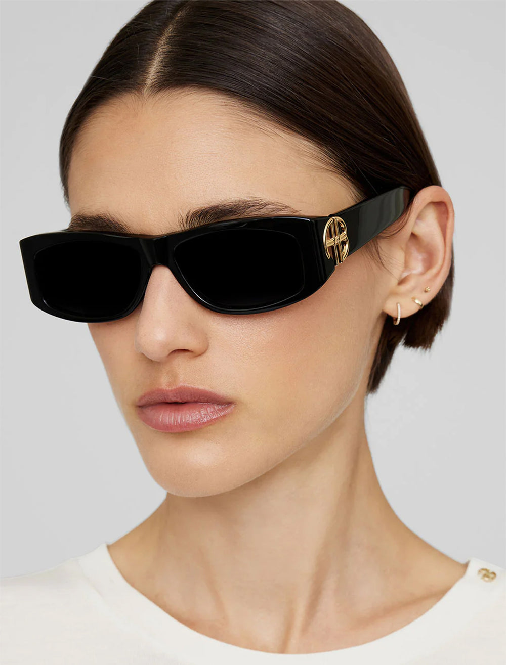 Model wearing Anine Bing's siena sunglasses in black and gold.