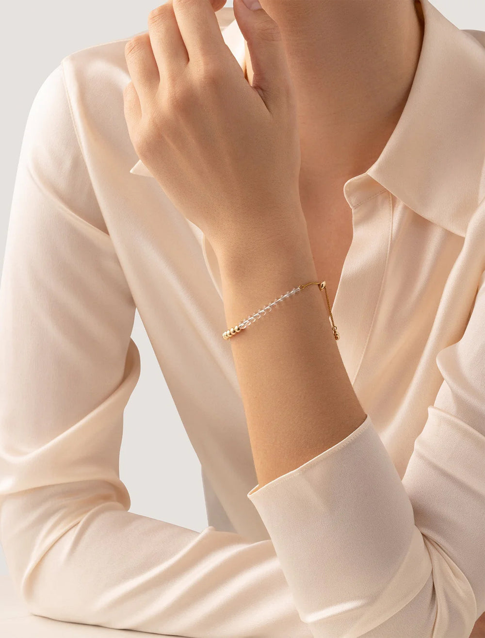model wearing pia bracelet in gold and clear