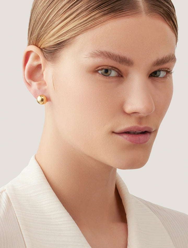 model wearing aurora studs in gold