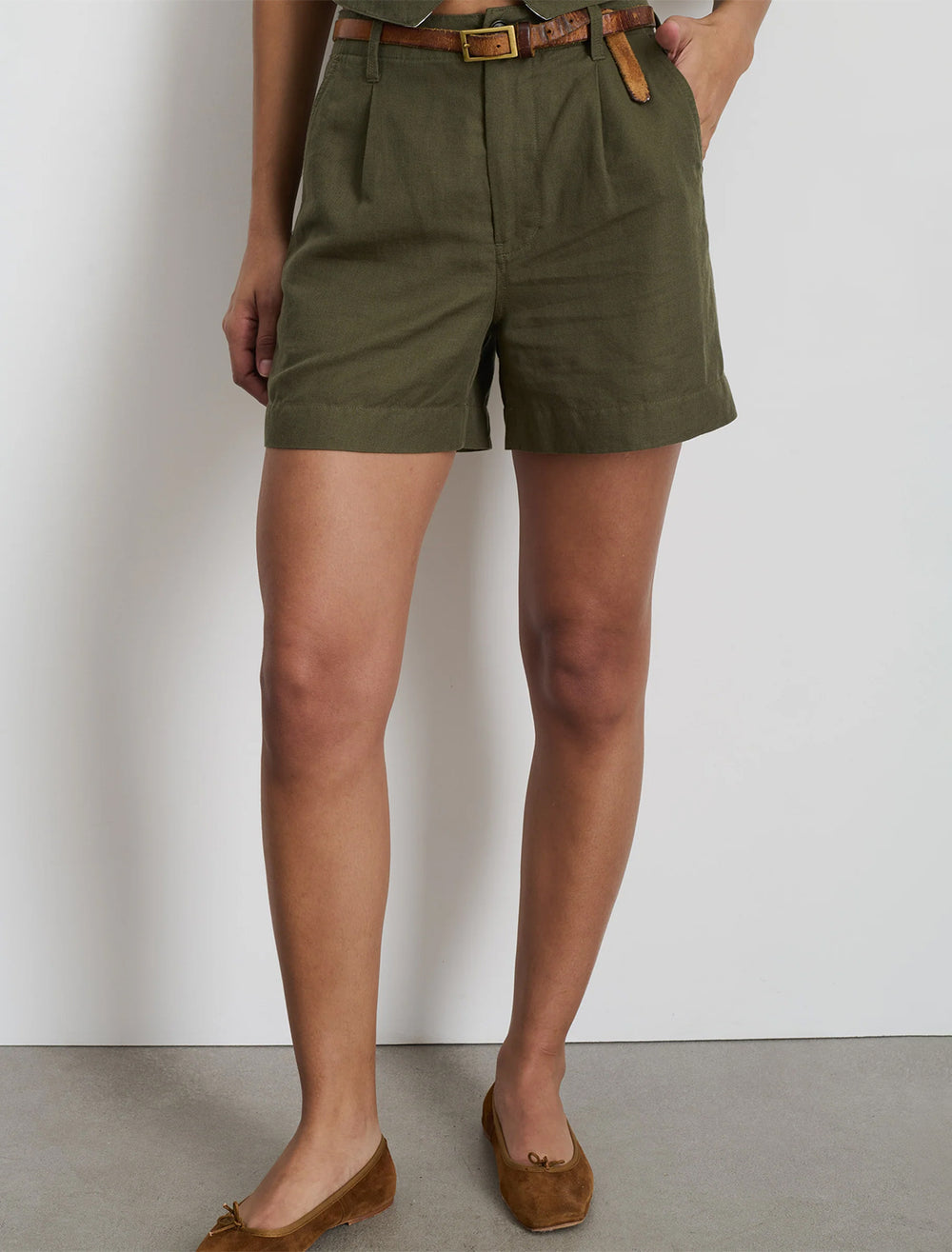 Model wearing Alex Mill's pleated twill shorts in pulgia olive.