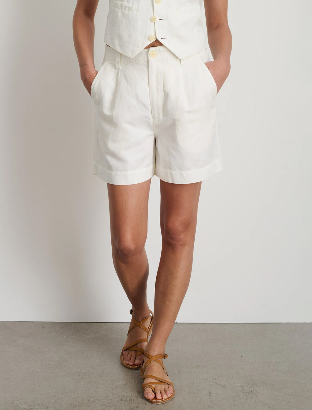 Model wearing Alex Mill's pleated twill shorts in ecru.