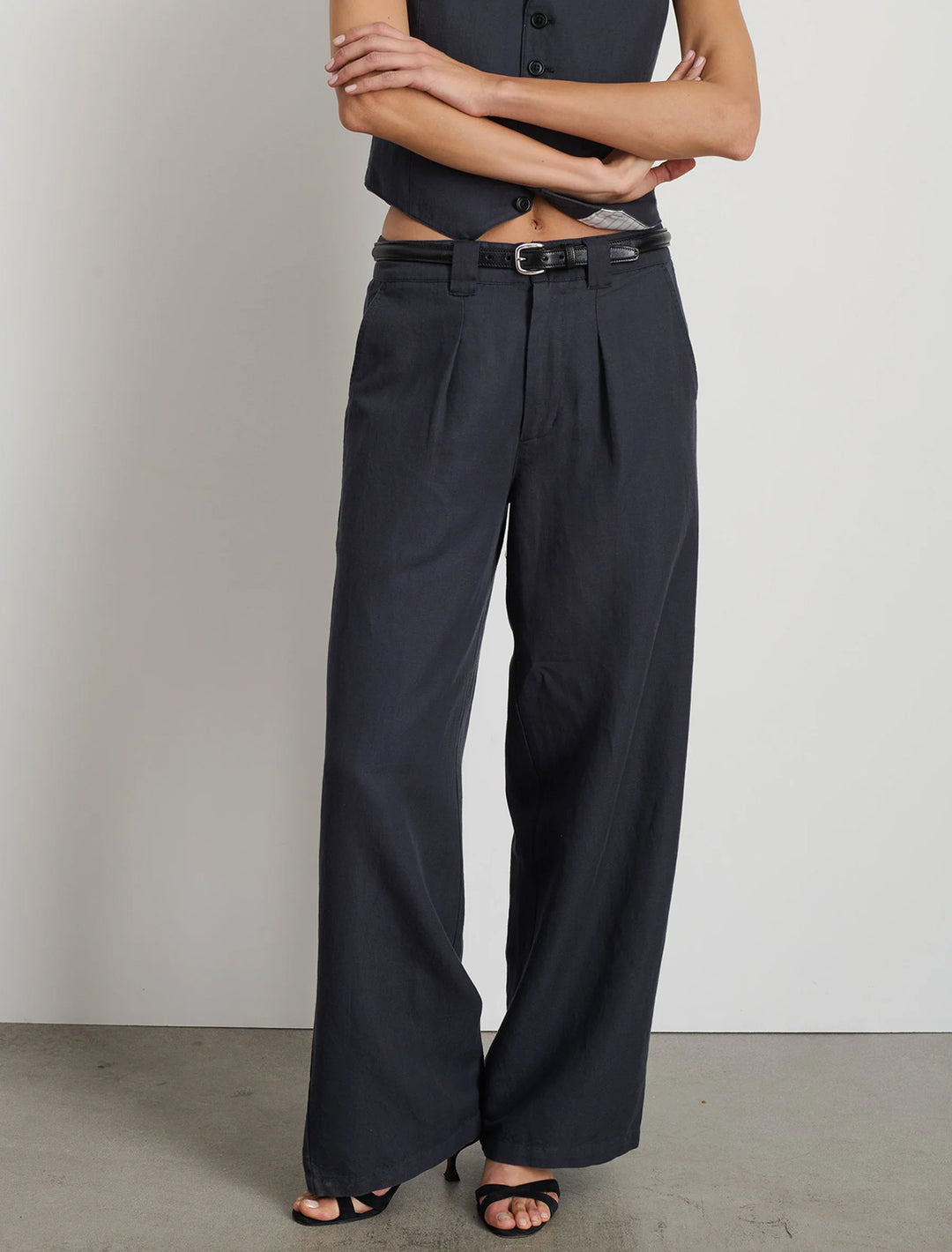 Model wearing Alex Mill's madeline twill pleated trouser in washed black.