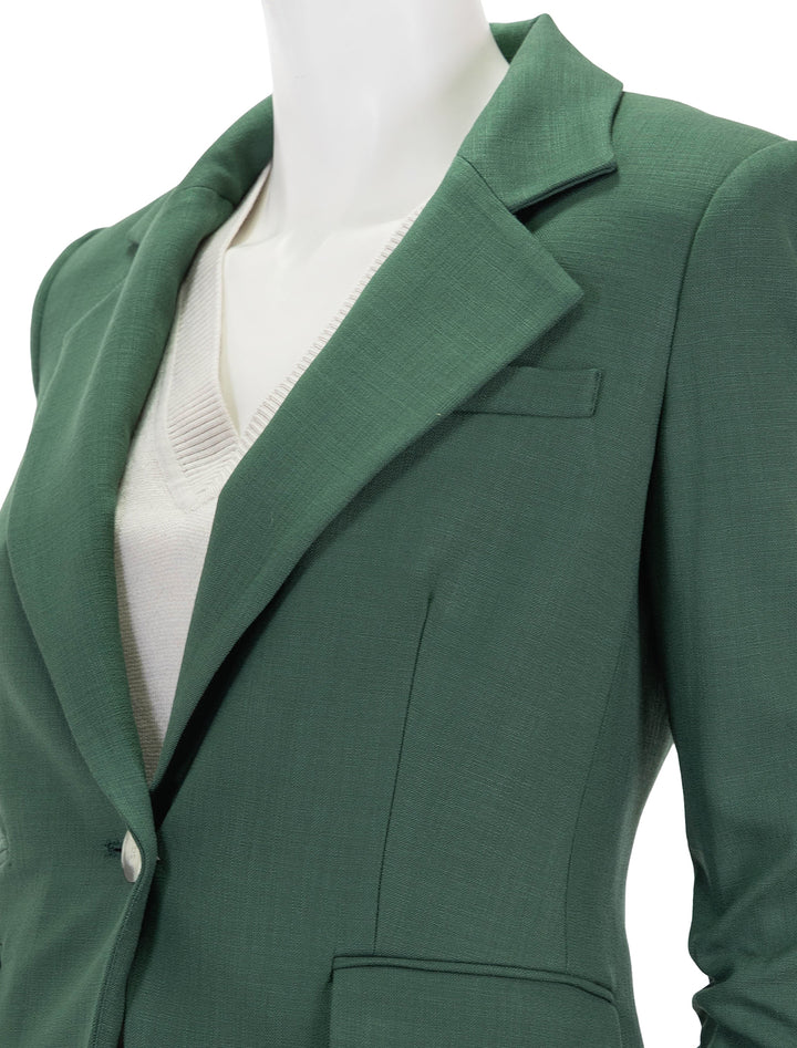 Close-up view of Veronica Beard's battista dickey jacket in forest.