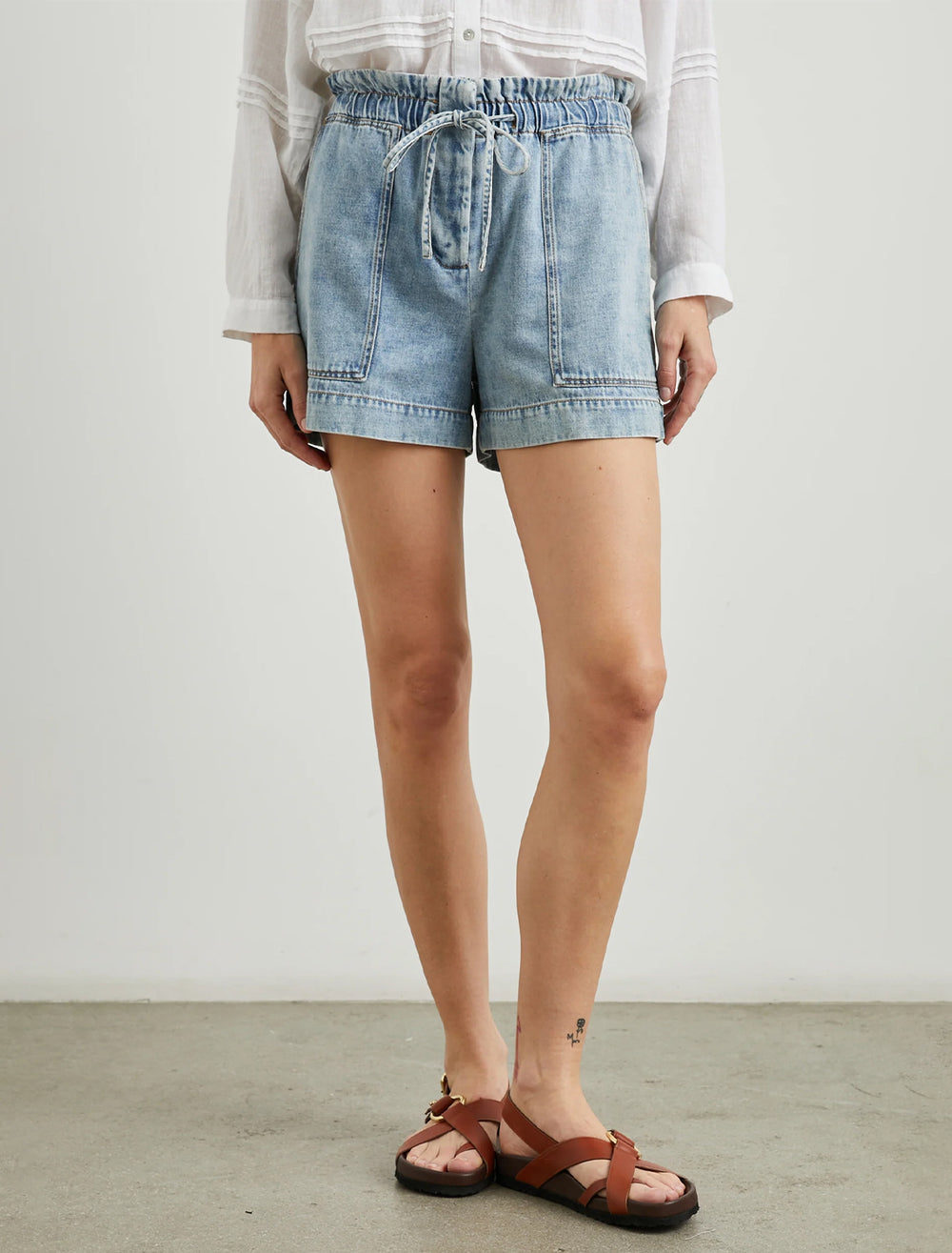 Model wearing Rails' foster shorts in faded indigo chambray.