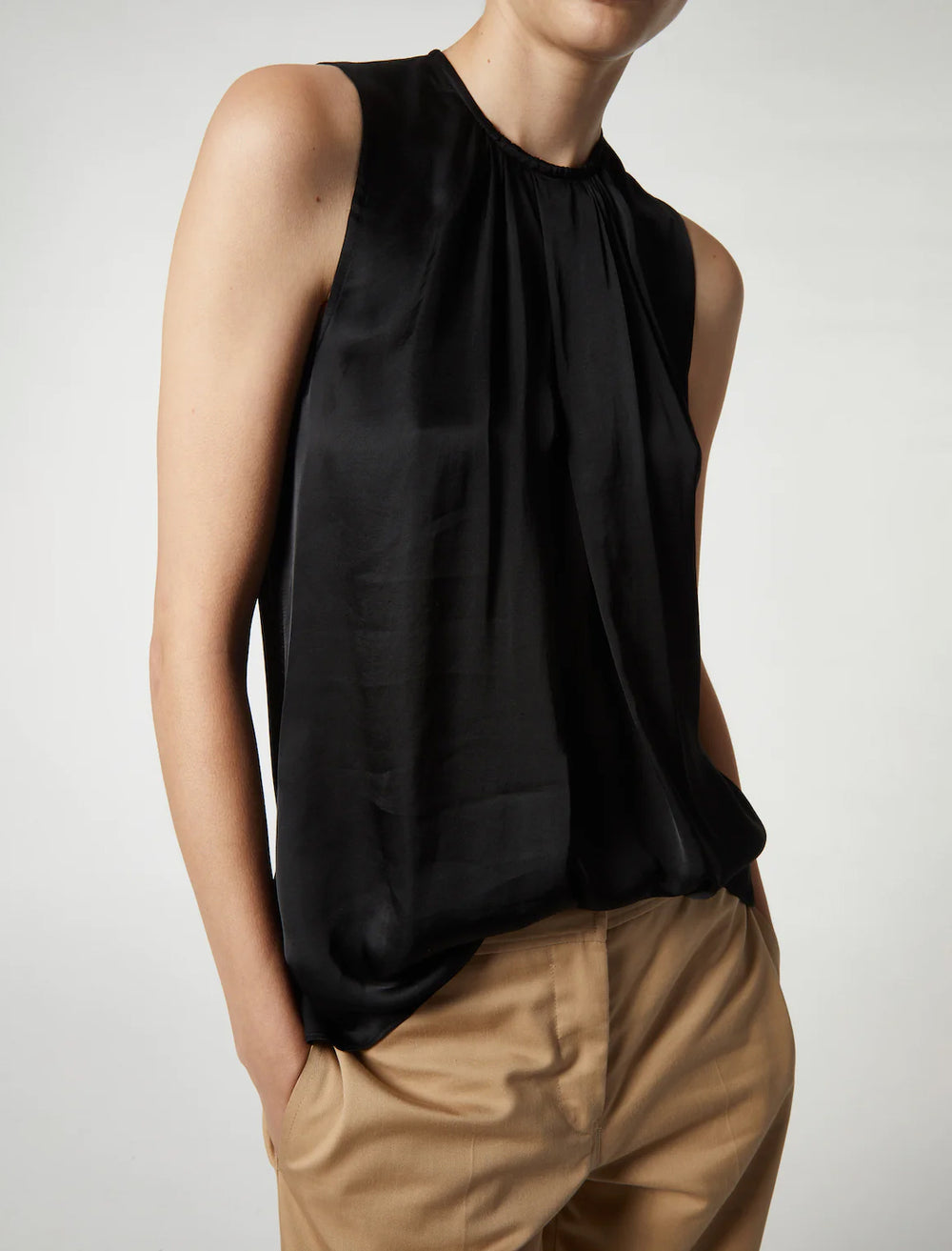 Model wearing Saint Art's sadie sleeveless blouse in black.
