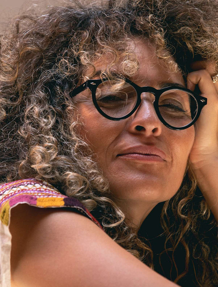 Model wearing Caddis' dogleg readers in polished black & vodka.