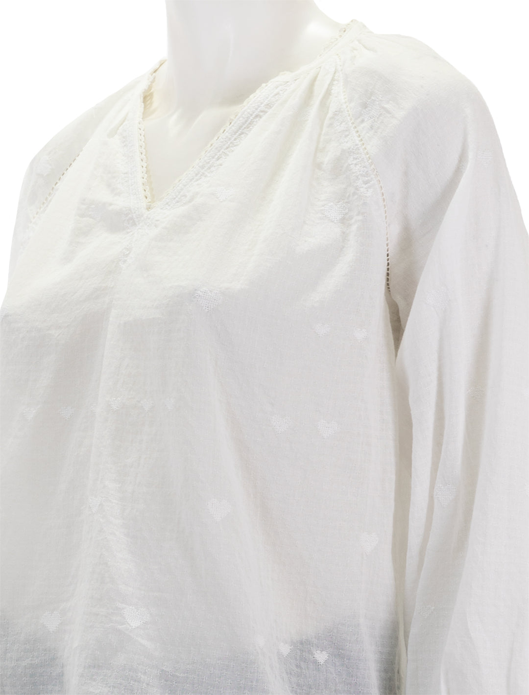 Close-up view of MABE's elani embroidered heart blouse in white.