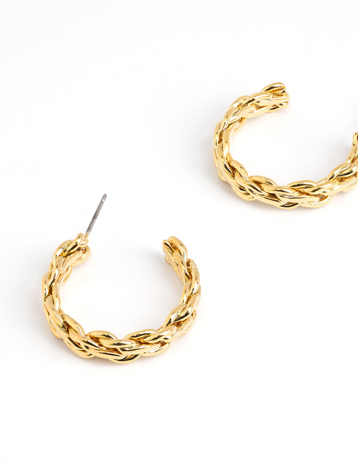 Stylized laydown of AV Max's Triple Twist Hoops in Gold.
