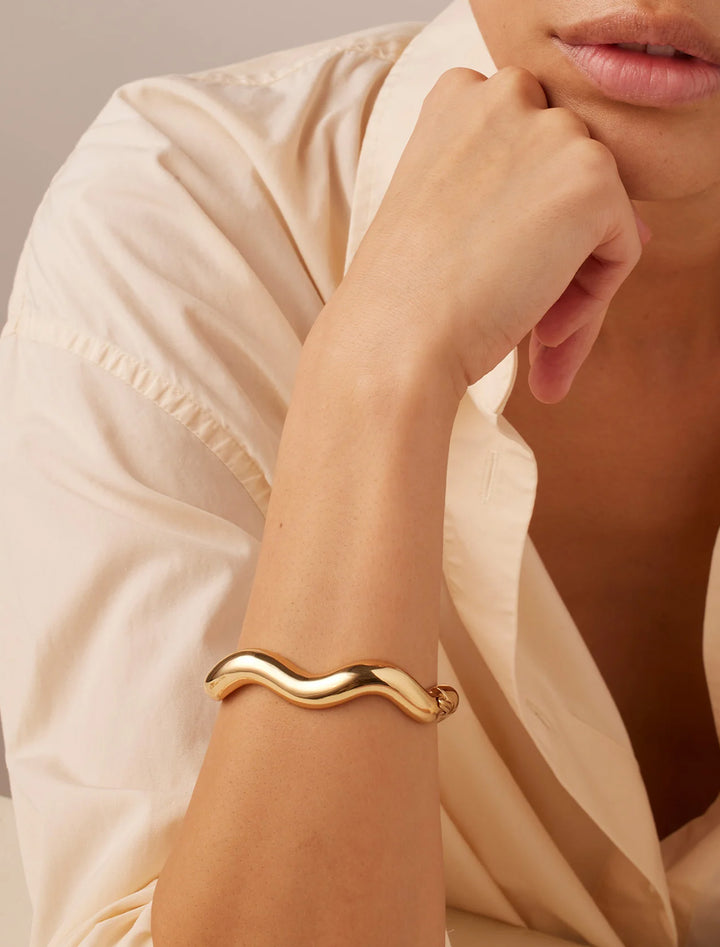 Model wearing Jenny Bird's ola bangle in gold.