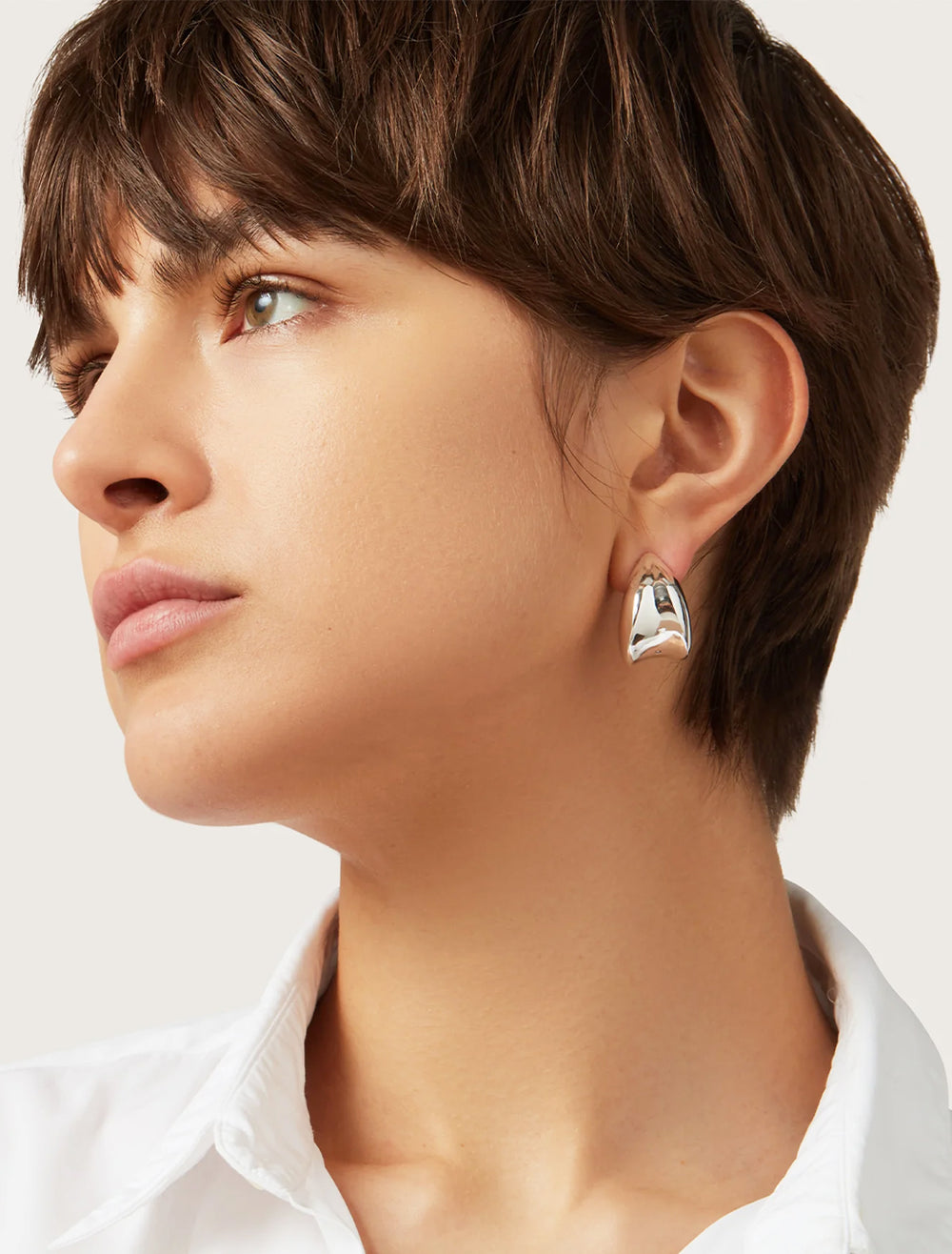 Model wearing Jenny Bird's nouveaux puff earrings in silver.
