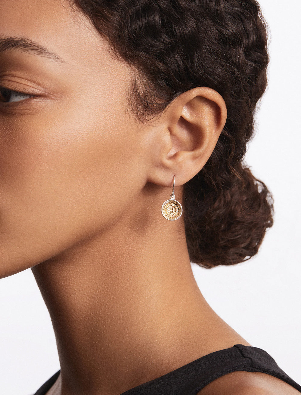 Model wearing Anna Beck's classic dish drop earrings in two tone.