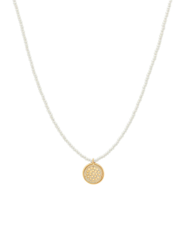 Front view of Anna Beck's delicate beaded pearl circle pendant necklace in gold.