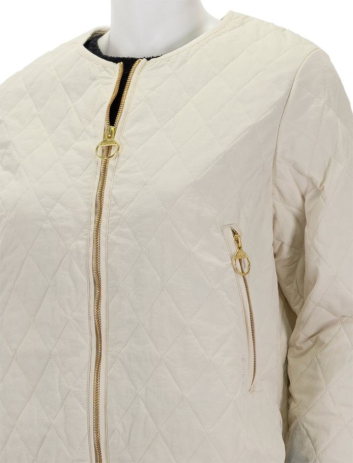 Close-up view of Barbour's caroline quilted jacket in antique white.