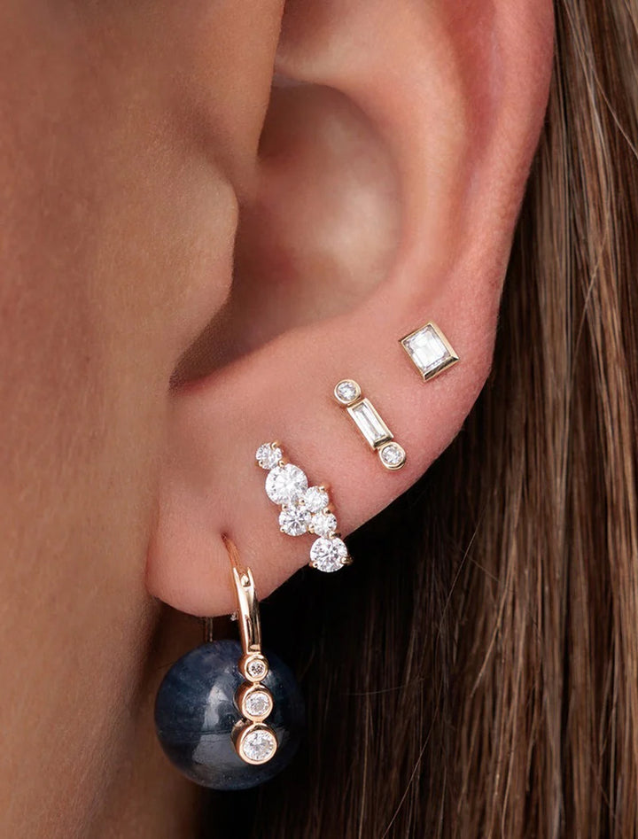 model wearing baguette and round bezel studs