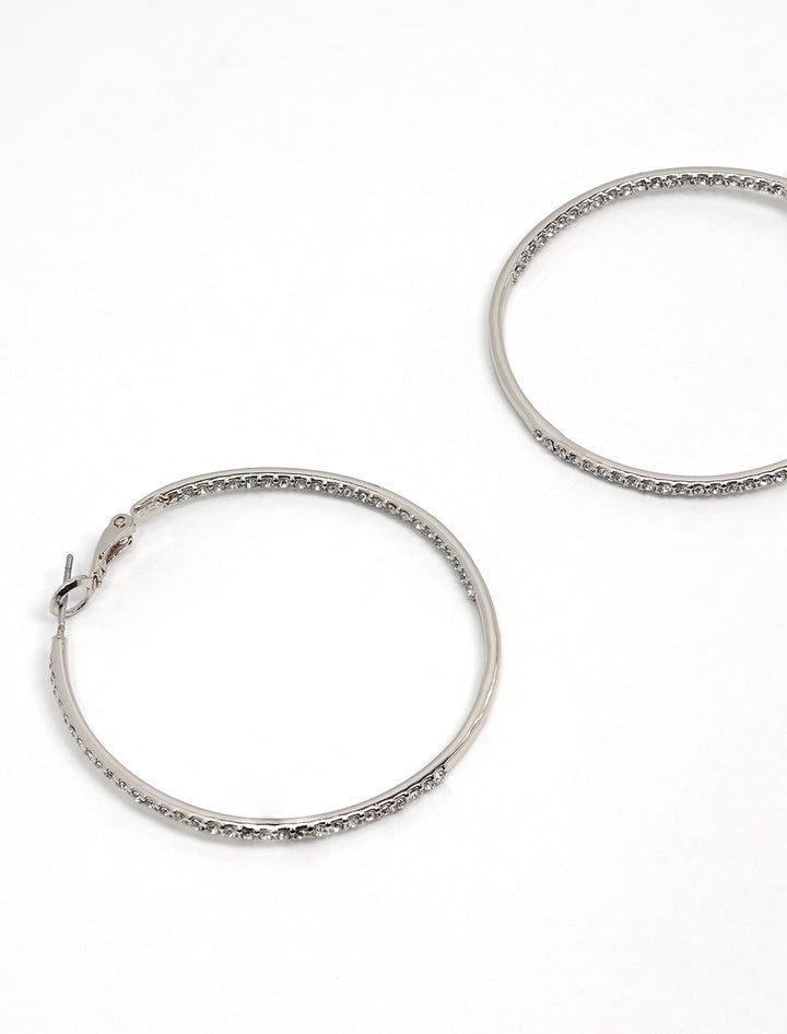 Stylized laydown of AV Max's large rhinestone hoops in silver.
