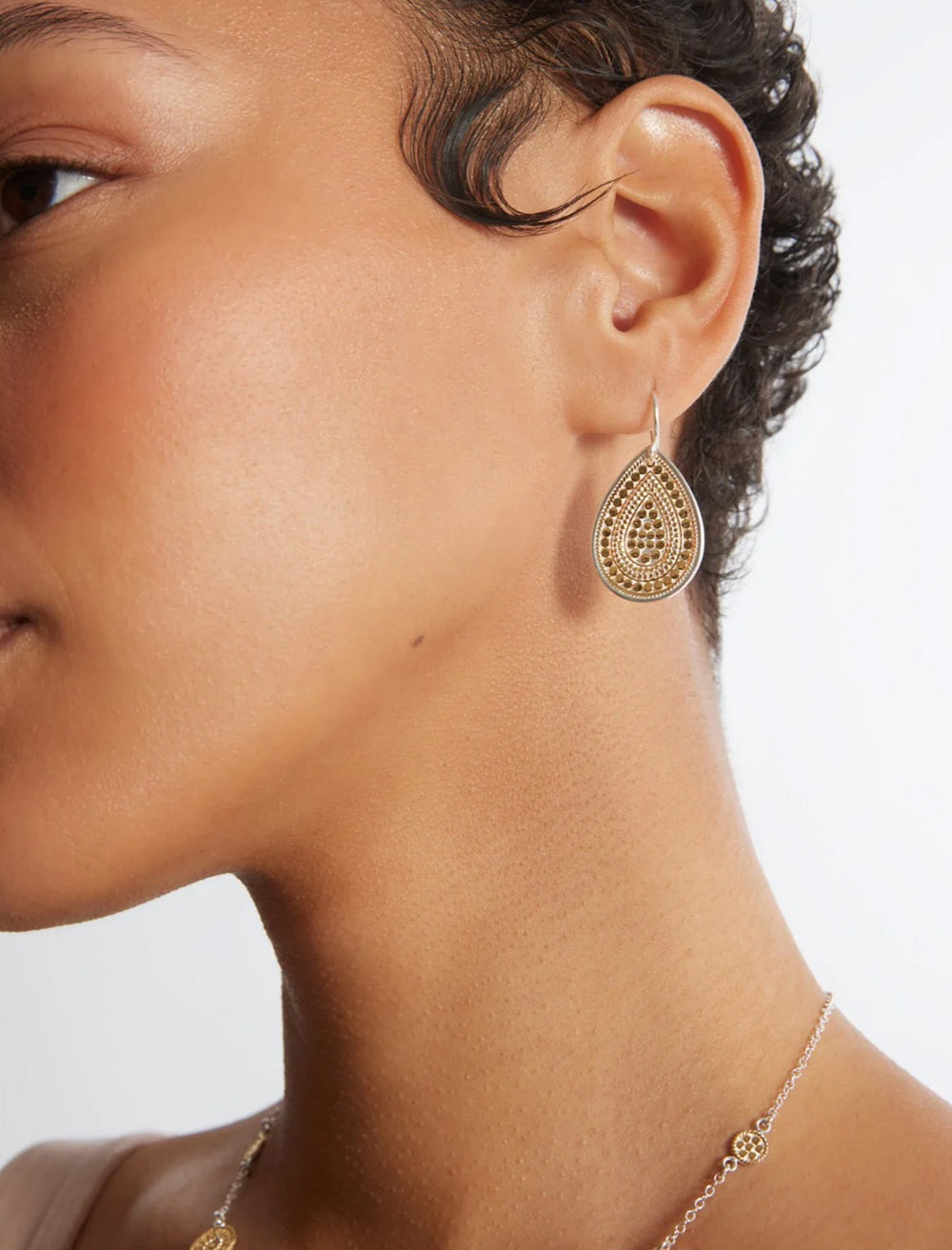 Model wearing Anna Beck's teardrop earrings in gold