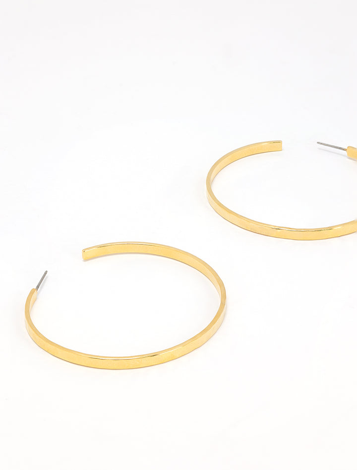 Stylized laydown of AV Max's hammered gold hoops.