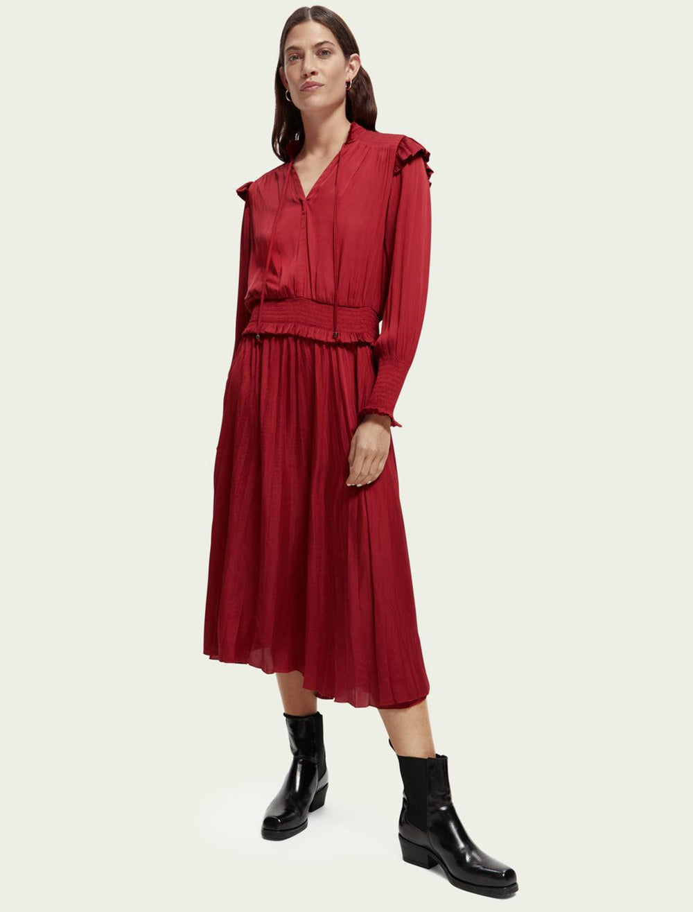 Model wearing Scotch & Soda's Smock Stitch Midi Dress in Deep Raspberry. Model styles the dress with black boots.