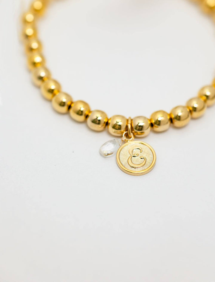 close up view of beaded monogram bracelet | E charm and gem