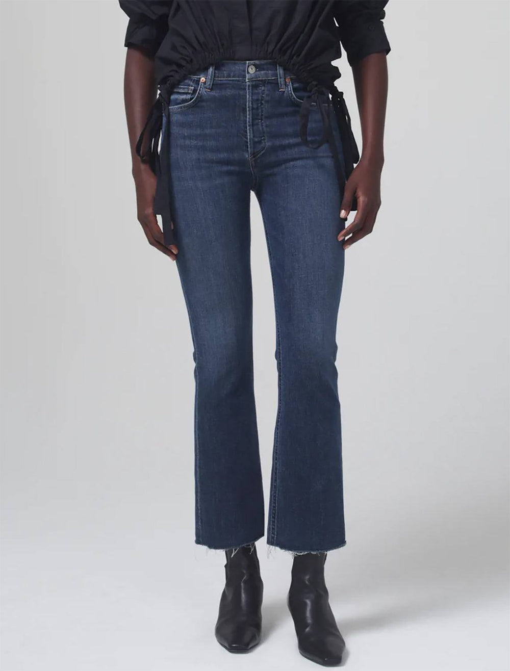 Model wearing Citizen of Humanity's Isola Cropped Boot in Undercurrent. Model pairs the jeans with a black shirt and black boots.