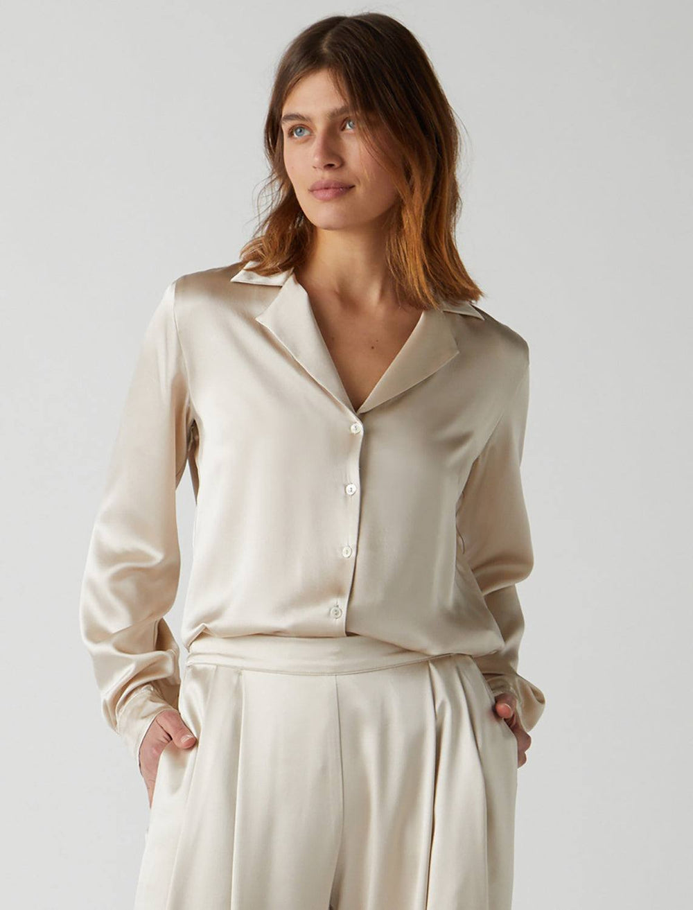 Model wearing Velvet's Soho Blouse in Oyster. Model pairs the blouse with a pair of matching slacks.