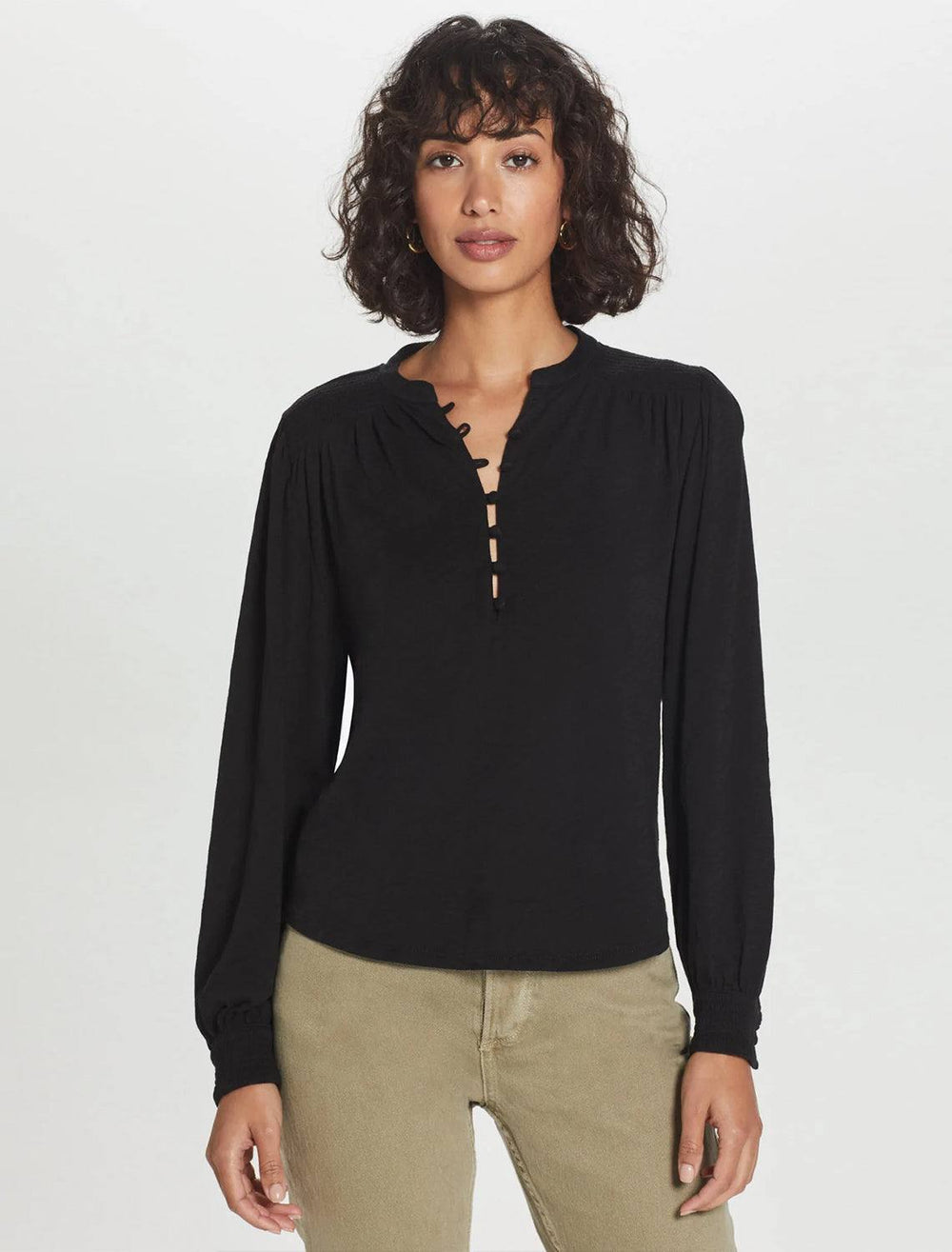 model wearing peasant blouse with smocking in black with tan jeans