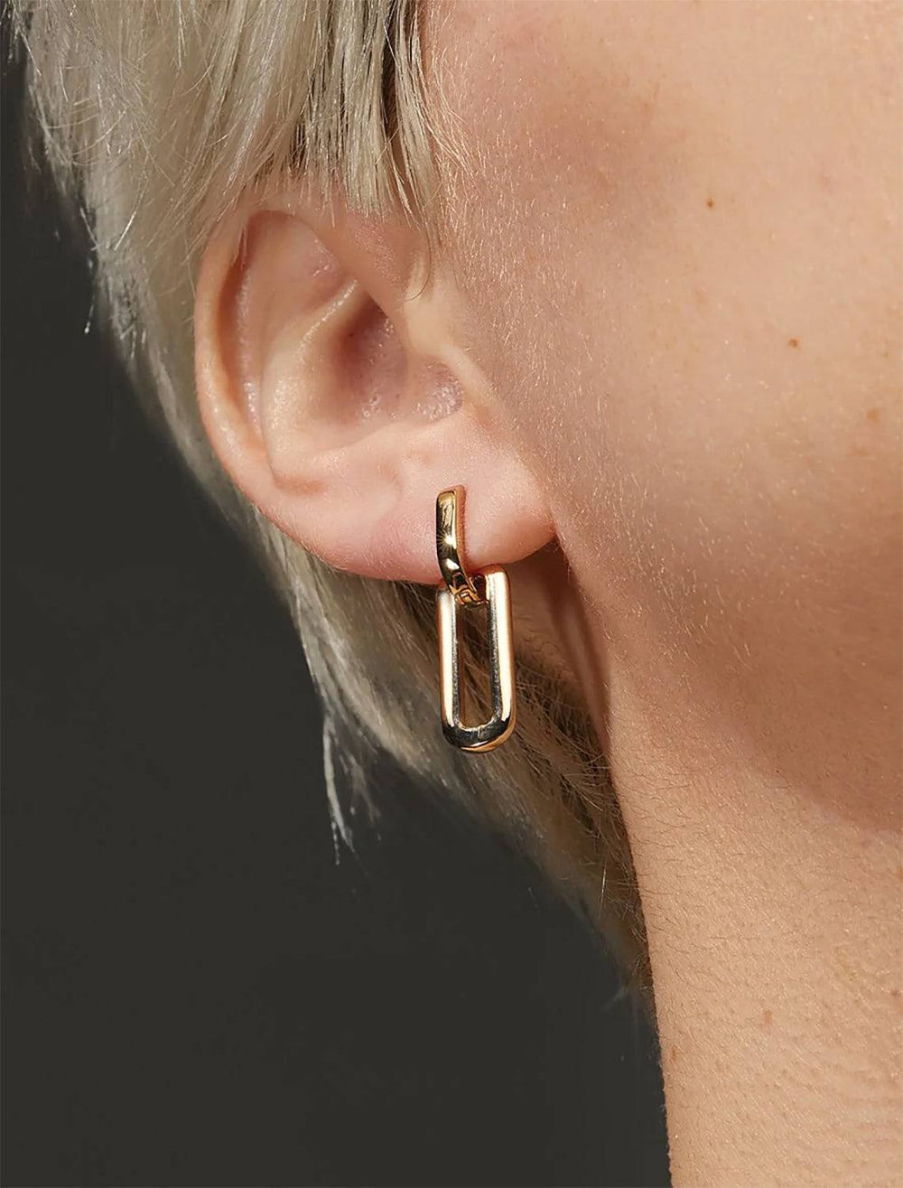 Model wearing Jenny Bird's Teeni Detachable Link Earrings in Gold Tone Dipped Brass.