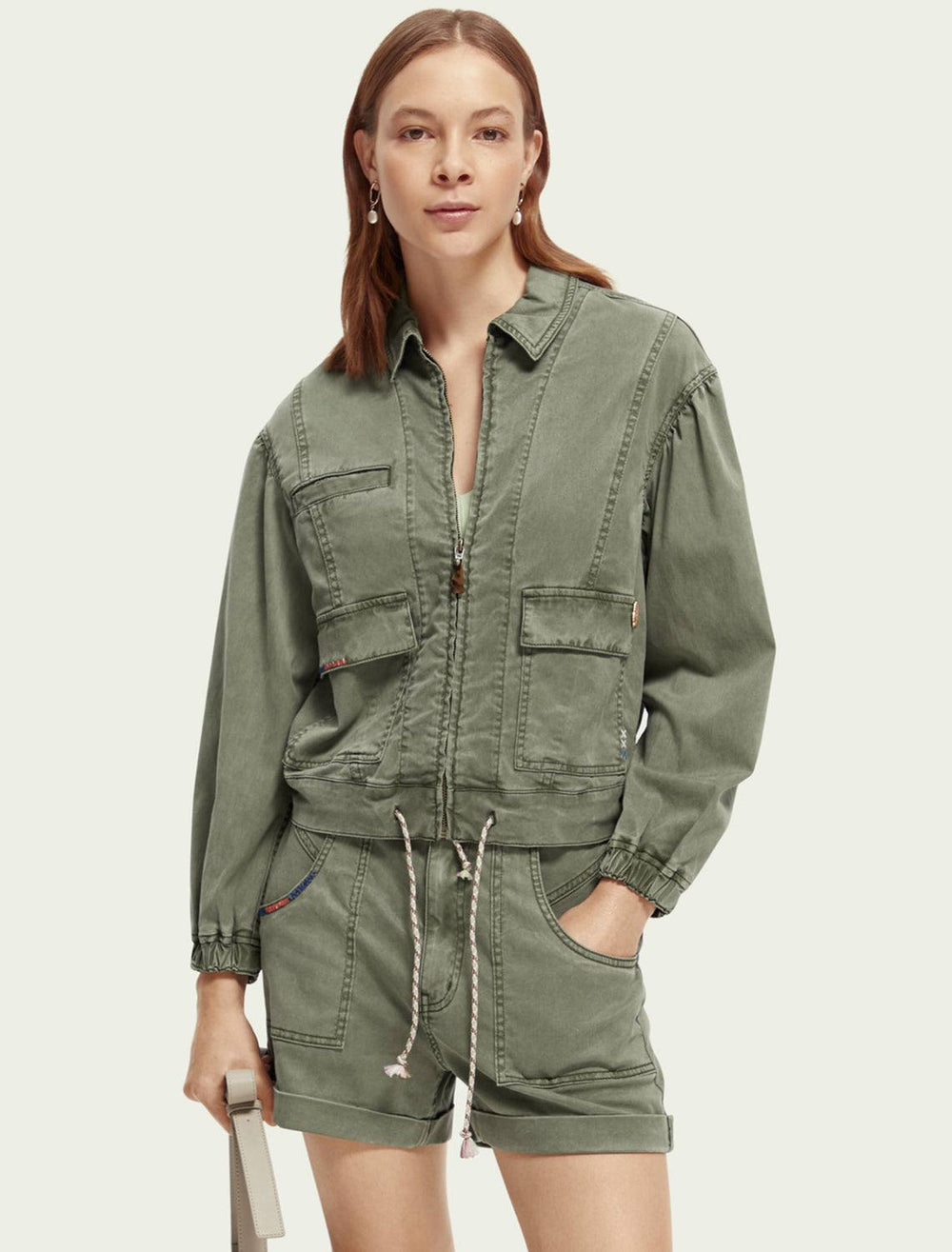 Model wearing Scotch & Soda's utility jacket in olive green.