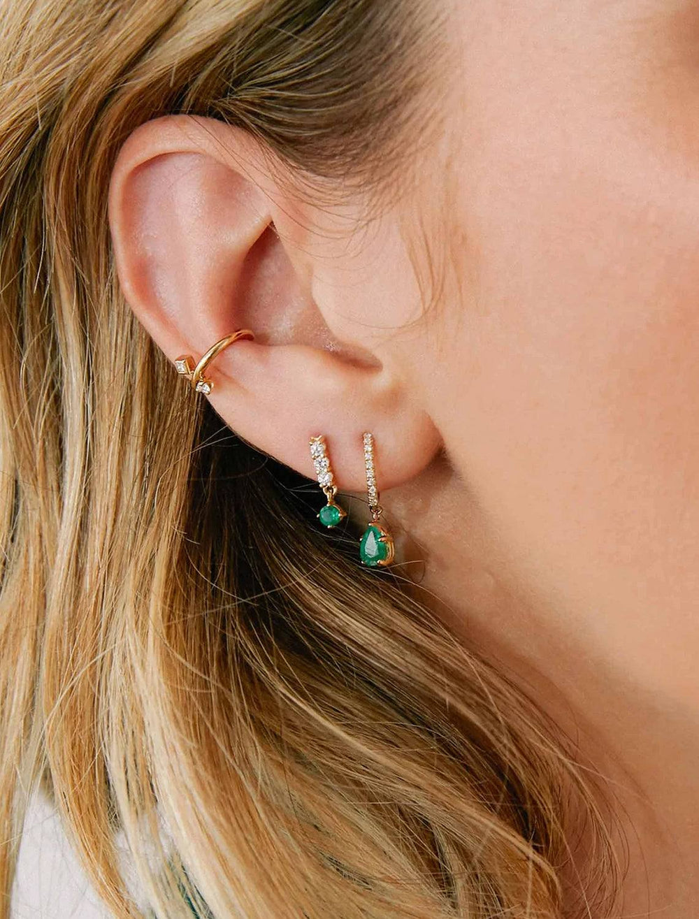 Close-up view of Zoe Chicco's 14k diamond bar earrings with emerald drops.