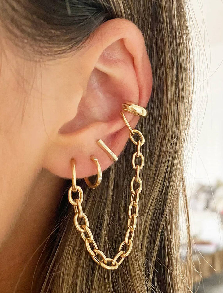 Model wearing Zoe Chicco's 14k huggie hoops with bead set diamonds.