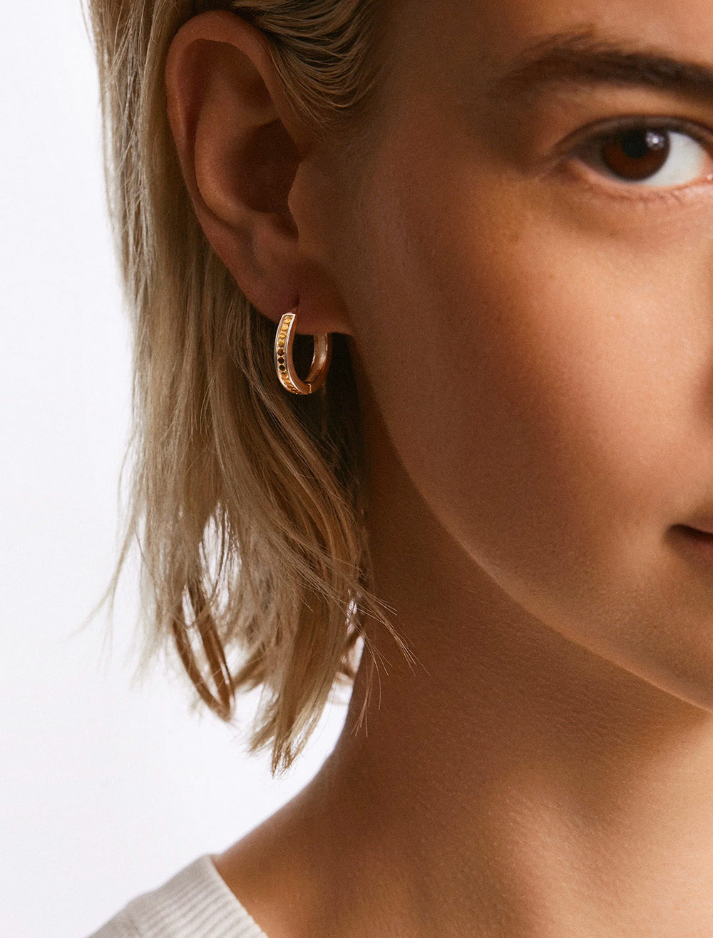 Model wearing Anna Beck's classic small hinge hoops.