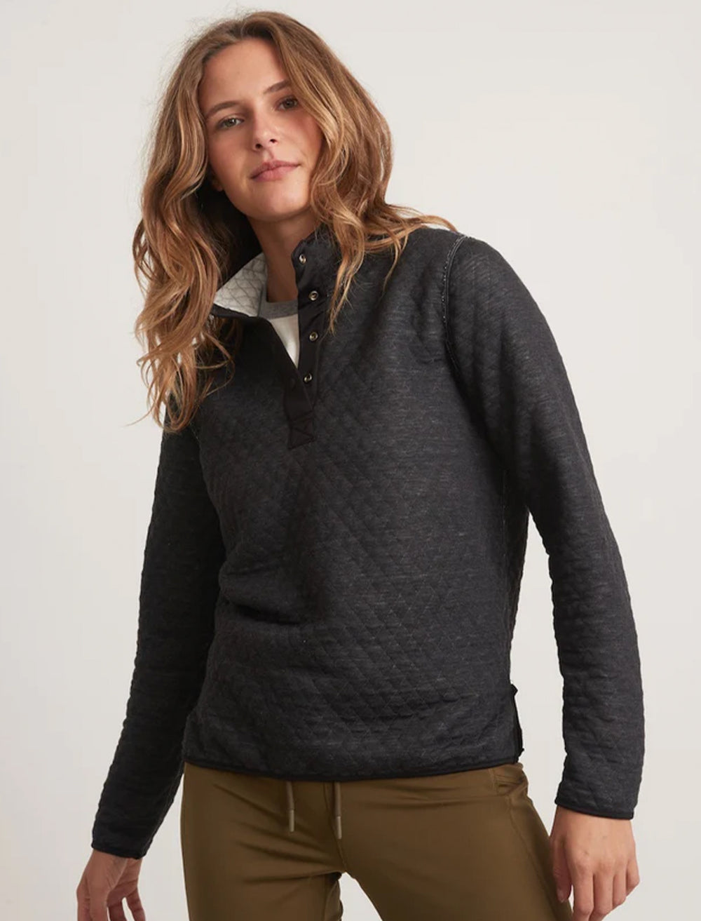 Model wearing the reverse side of Marine Layer's corbet reversible pullover in white and black.