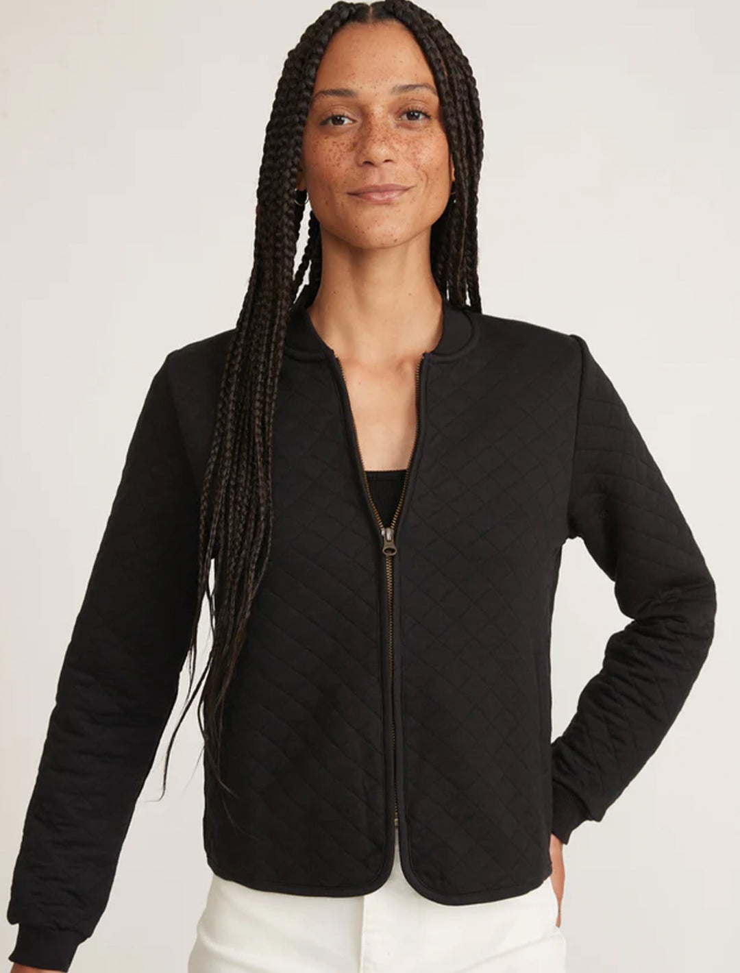 Model wearing Marine Layer's corbet quilted bomber in black.