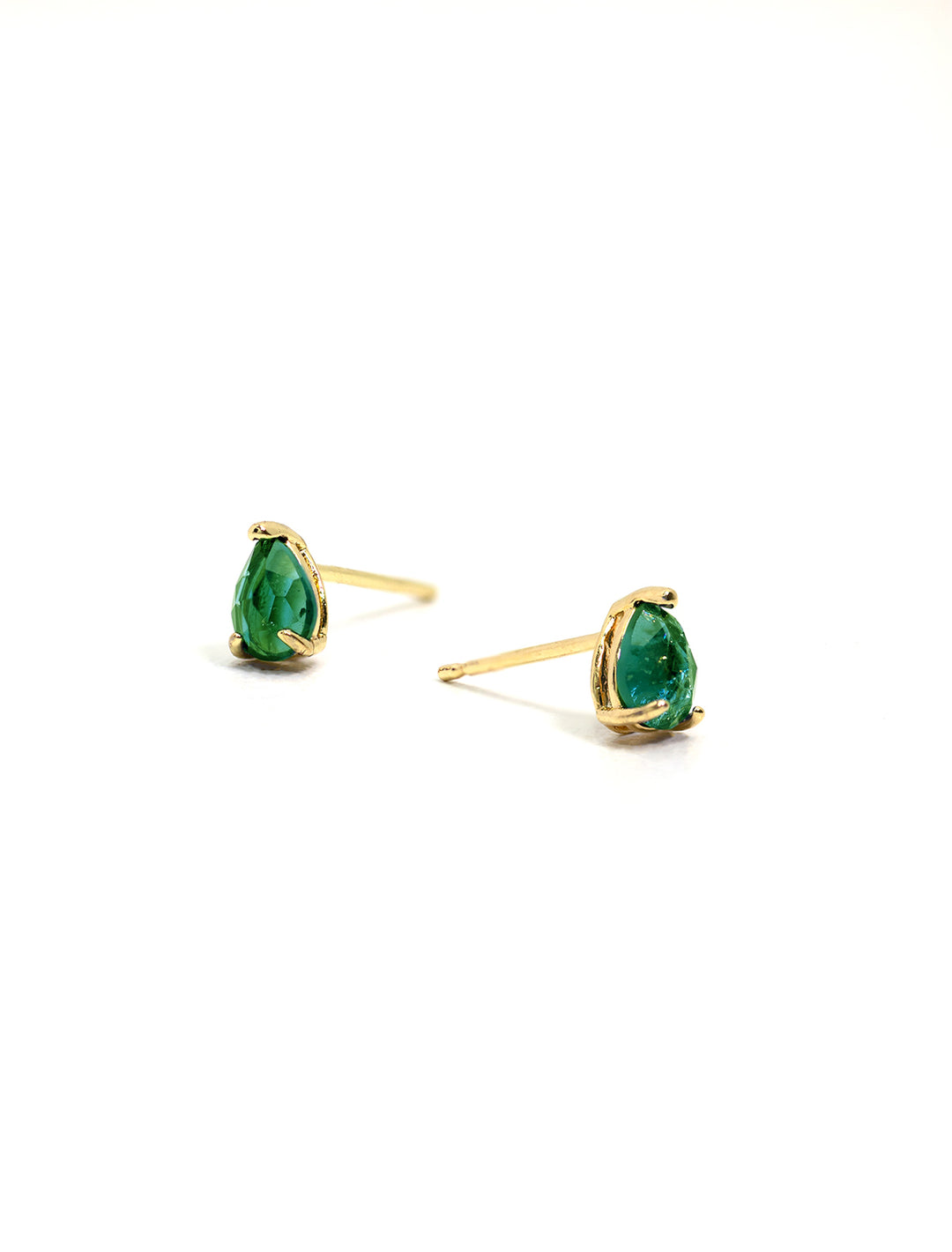 Stylized laydown of Tai's pear shaped stud in emerald.