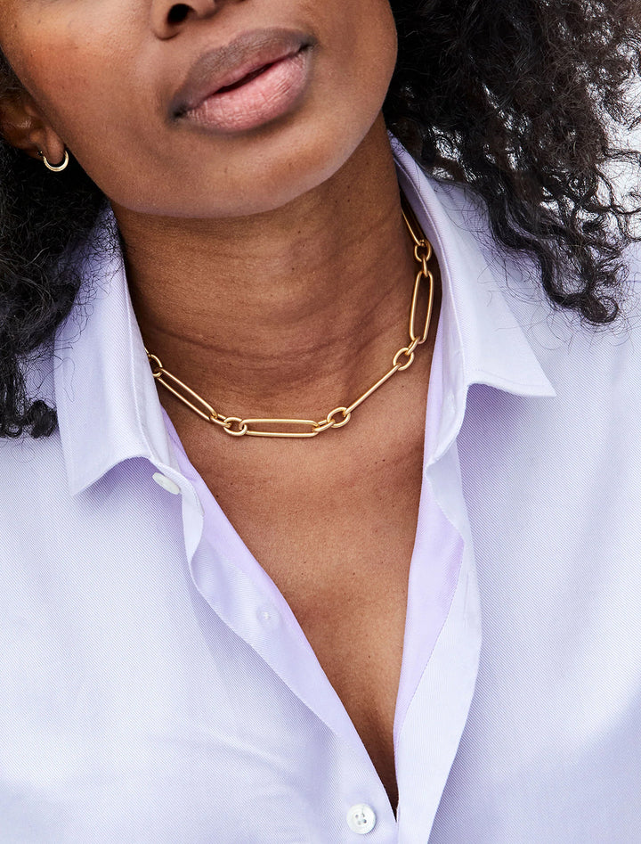 Model wearing Clare V.'s convertible chain necklace in gold as a choker.