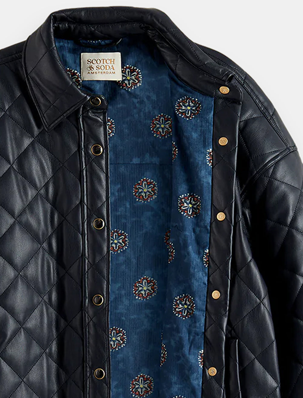 Close-up view of Scotch & Soda's faux leather quilted shirt jacket in night, featuring the unique lining.