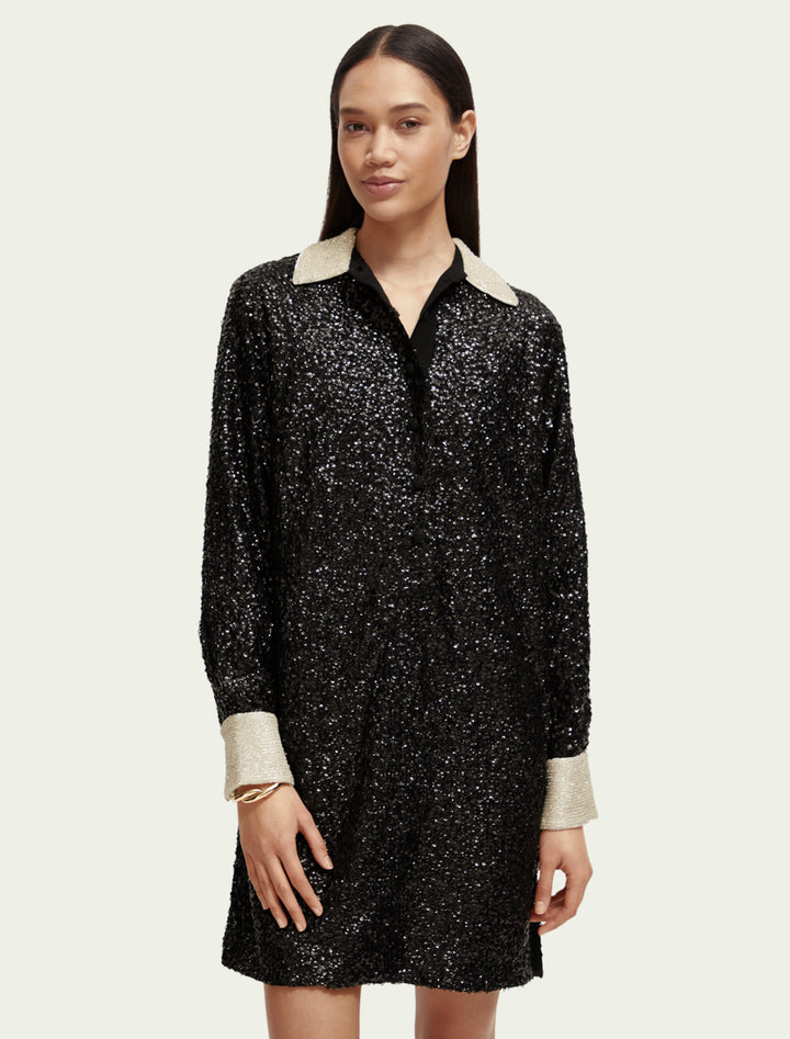 Model wearing Scotch & Soda's sequin mini dress in black.
