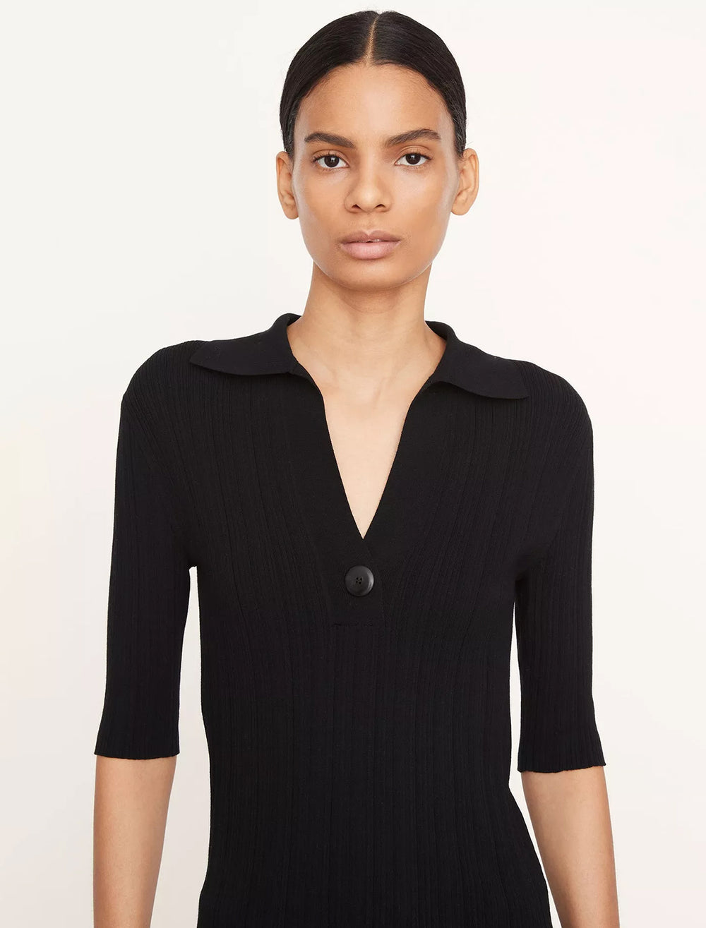 Model wearing Vince's elbow sleeve polo in black.