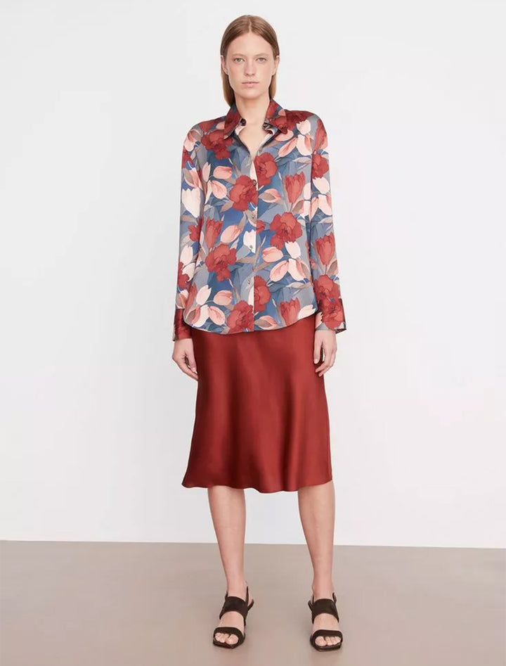 model wearing nouveau magnolia long sleeve relaxed shirt with a silk, burgundy skirt and brown sandals 