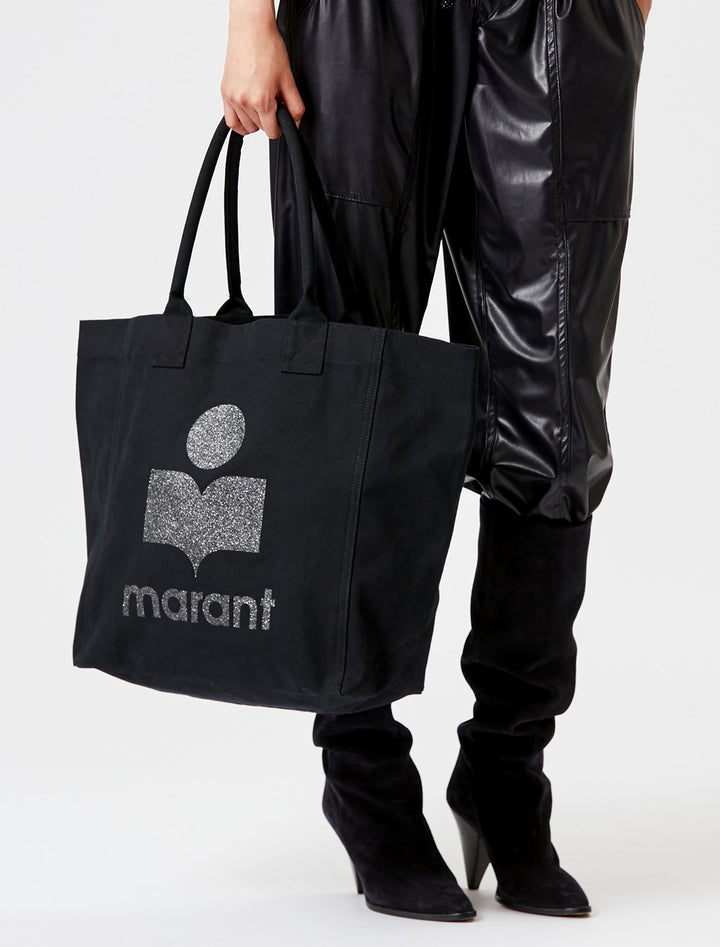 Model holding Isabel Marant Etoile's Yenky Canvas Tote in Black with Sparkle Logo.