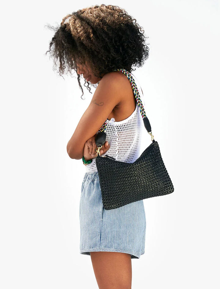 Model wearing Clare V.'s flat clutch with tabs black rattan.